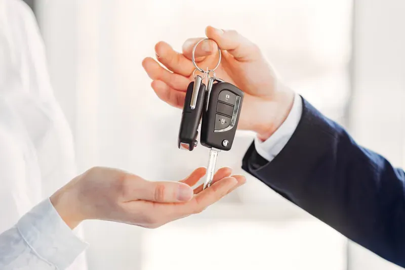 Passenger beside a sedan while arranging a chauffeur-driven journey