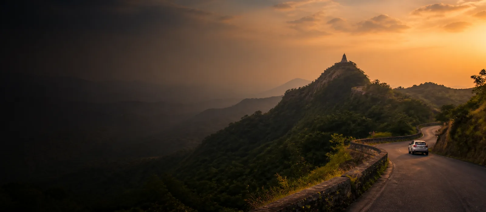 Pilgrimage road winding through the Maharashtra Sahyadri hills at sunset